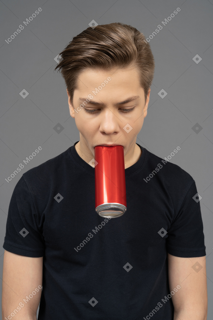 Close-up a male model holding red can with his mouth