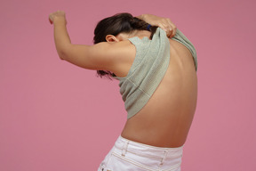 Mujer joven quitándose la camiseta