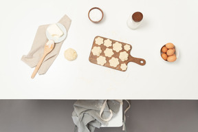 Une table avec des biscuits préparés pour la cuisson