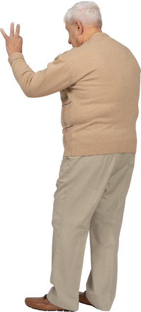 Vista laterale di un uomo anziano in abiti casual che mostra segno ok