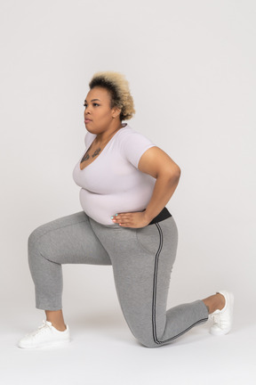 Plump african-american woman doing forward lunges