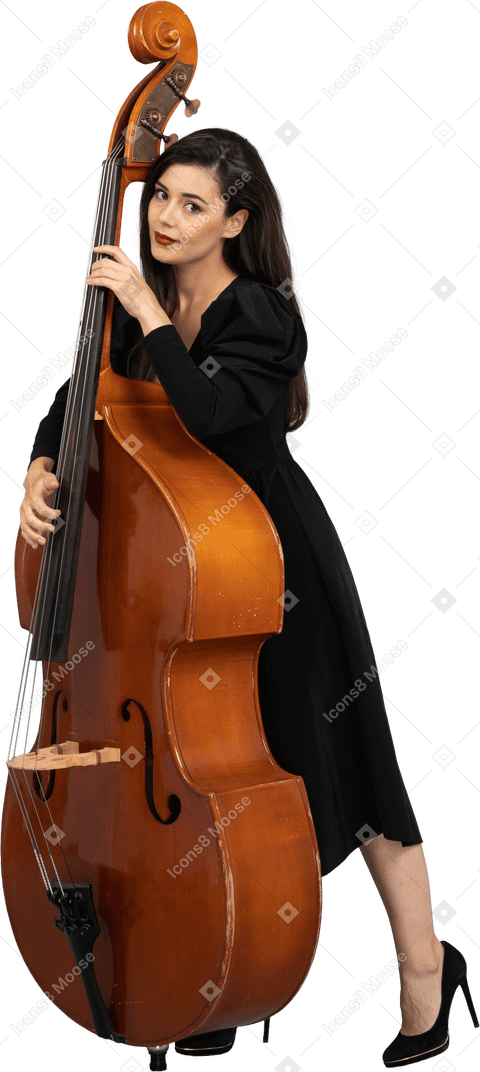 Vista de tres cuartos de una joven músico en vestido negro sosteniendo su contrabajo