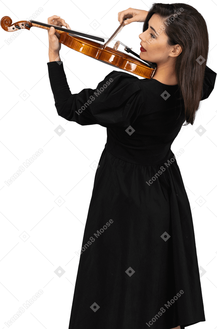 Close-up of a young cheerful lady in black dress playing the violin
