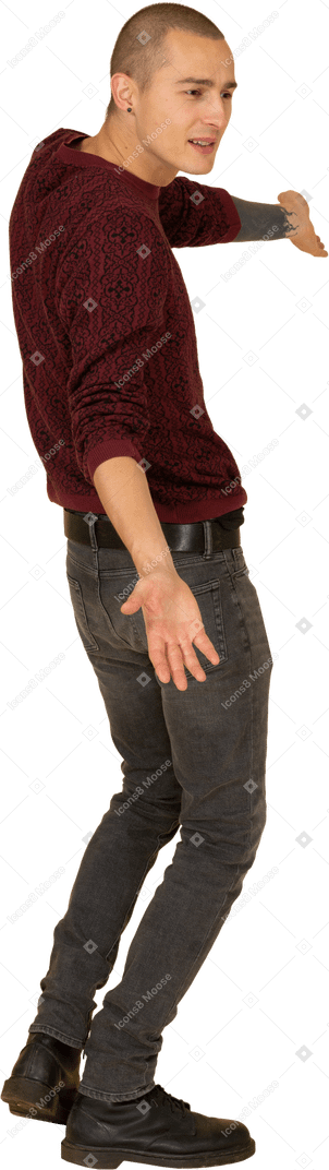 Vista laterale di un giovane uomo in pullover rosso alzando le braccia