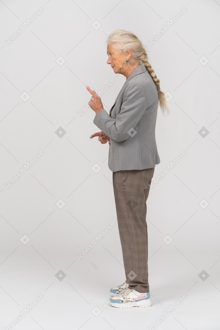 Vista lateral de uma senhora idosa de terno fazendo um aviso