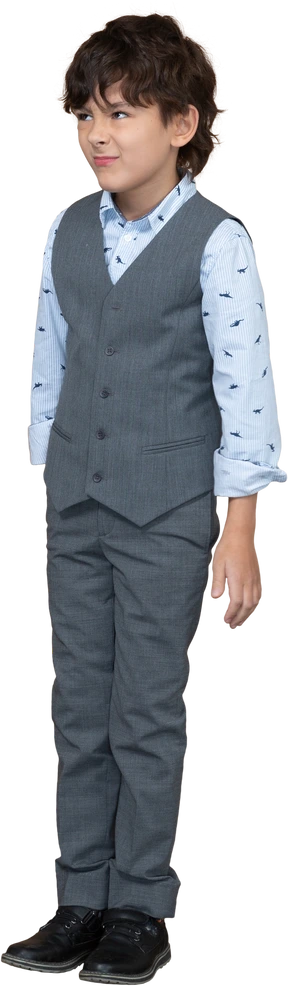 Front view of a cute boy in grey suit making faces