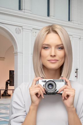 A woman holding a camera in front of her face