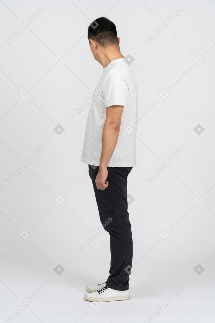 Mann in freizeitkleidung steht im profil und schaut zur seite