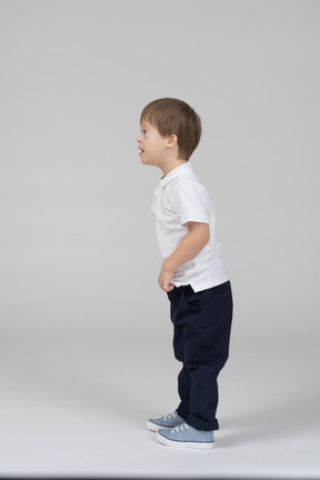 Vista lateral de un niño sorprendido inclinándose hacia adelante