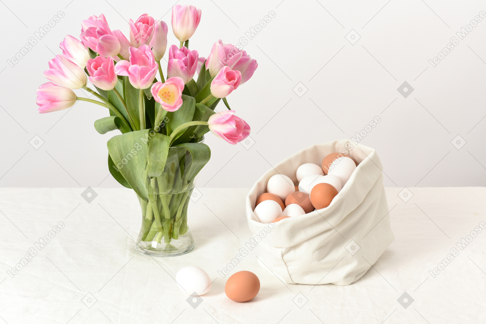 Sac en lin avec des œufs de poule et un bouquet de tulipes