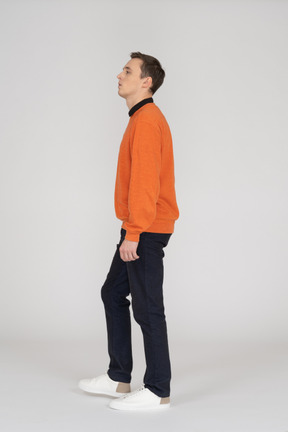 Junger mann im orangefarbenen sweatshirt zu fuß