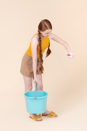 Teenage girl holding bucket and washcloth