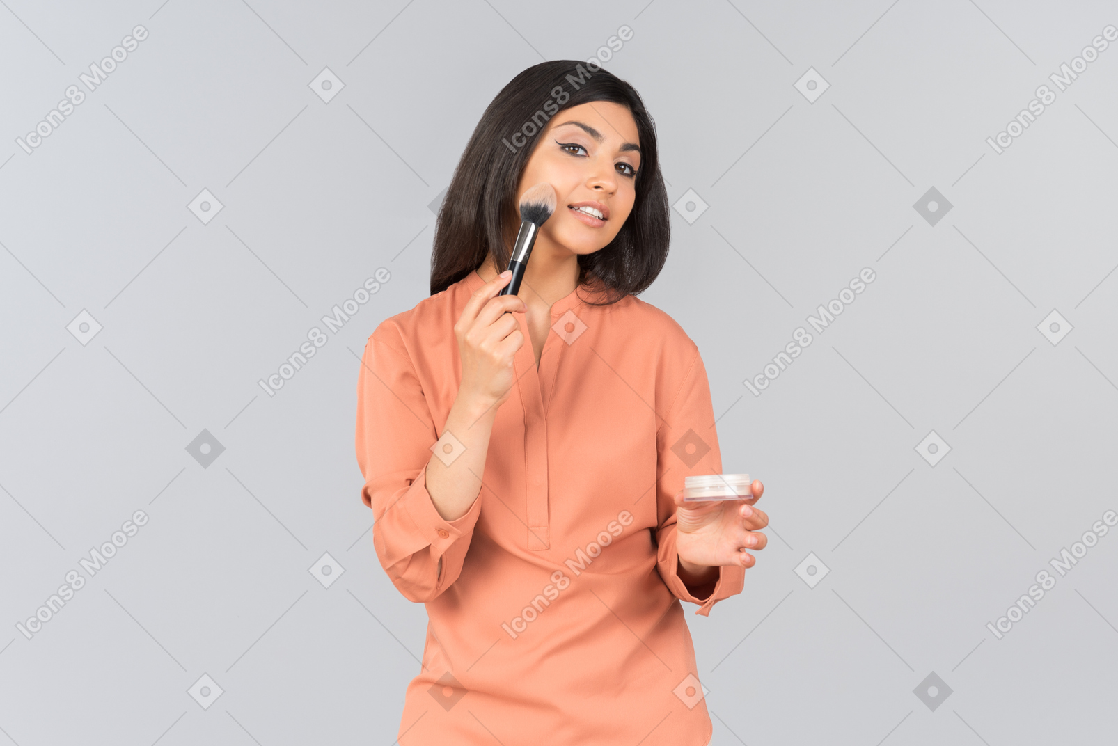 Indian woman applying face powder on her cheeks