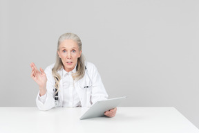 Doctora envejecida sosteniendo una tableta digital