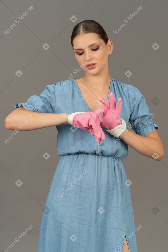 Young woman slipping off latex gloves