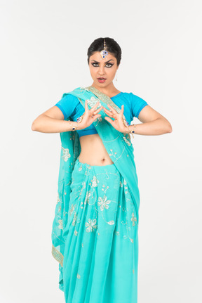 Jeune femme indienne en sari bleu debout en position de danse