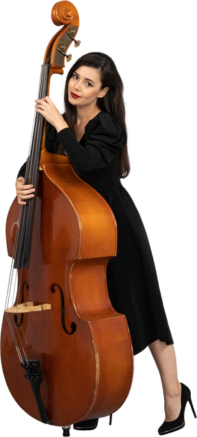 Vista di tre quarti di una giovane musicista in abito nero che tiene il suo contrabbasso