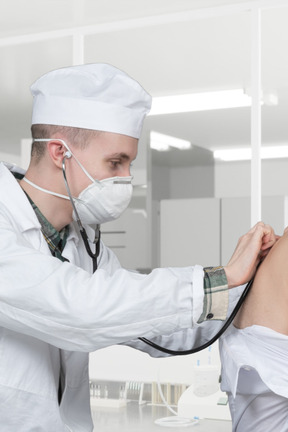 A doctor examining a woman's stomach with a stethoscope