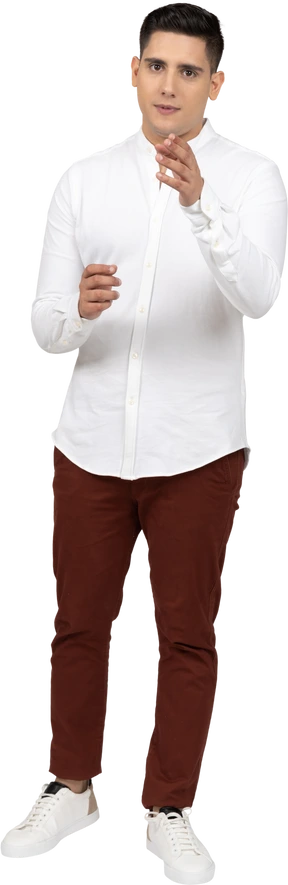 Front view of a young latino man looking and gesticulating at camera