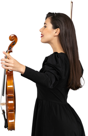 Side view of a female violin player in black dress outspreading hands