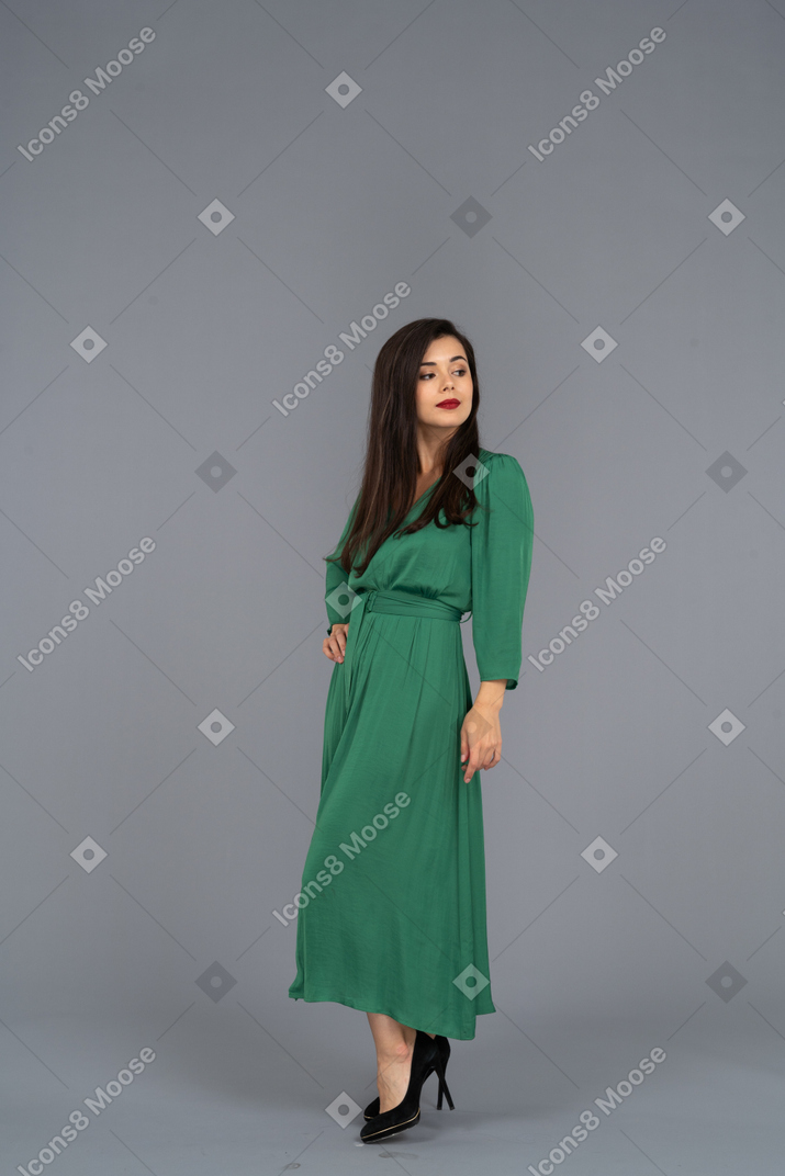 Вид в три четверти молодой леди в зеленом платье, положившей руку на бедро