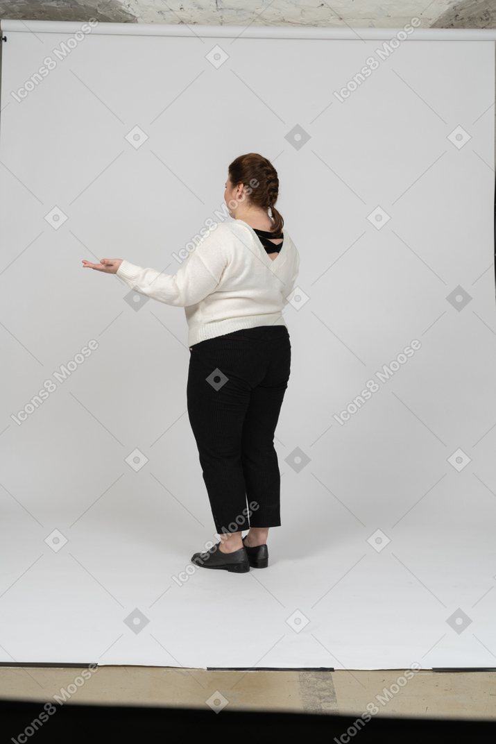 Vista laterale di una donna grassoccia in maglione bianco che fa gesti