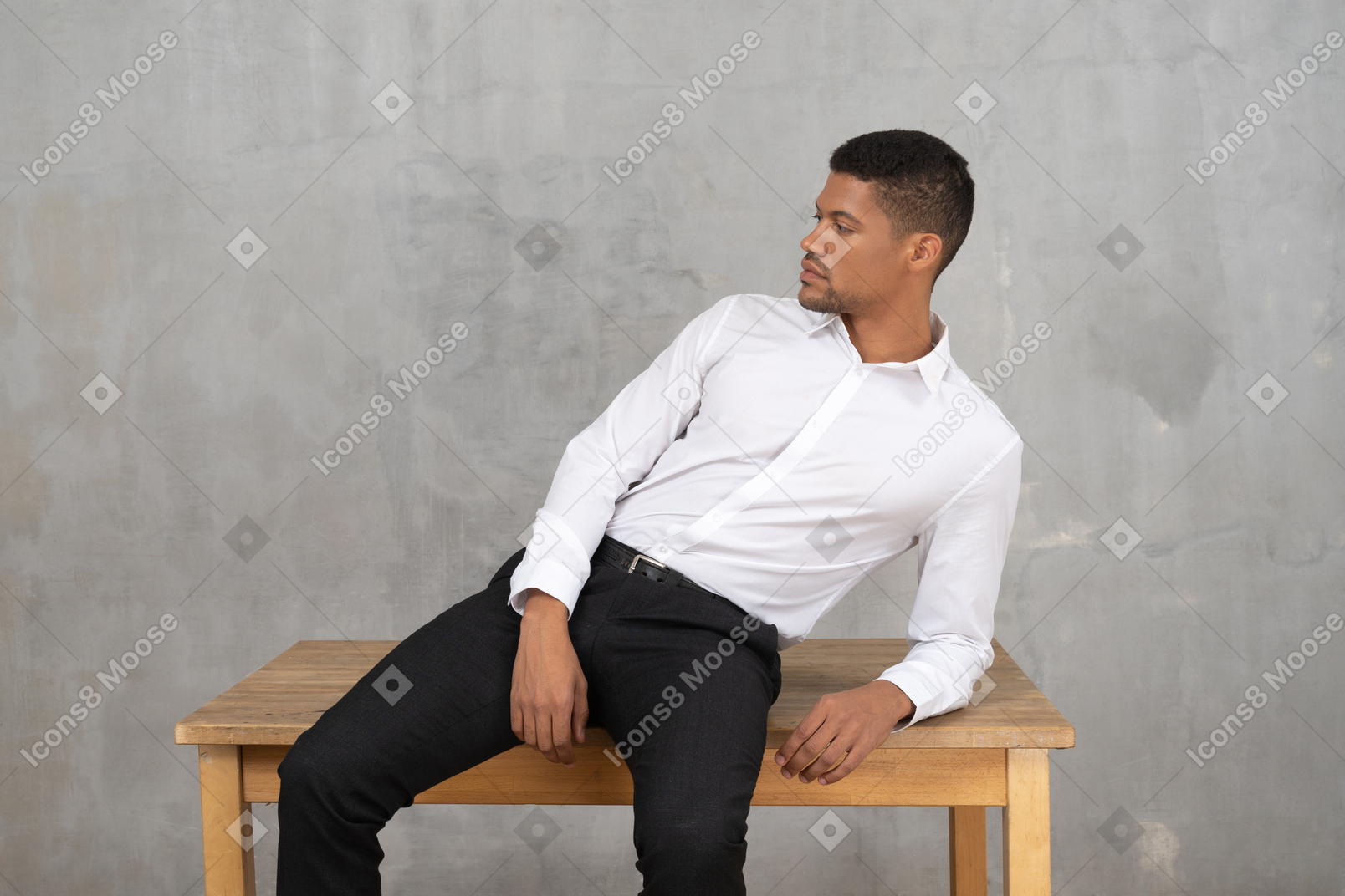 Расслабленный мужчина в офисной одежде сидит на столе