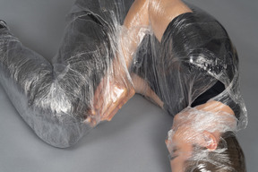 Close up of young man wrapped in plastic