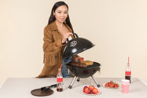 Jeune femme asiatique ouvrant un grill