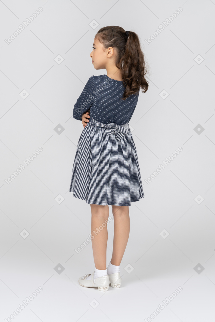Three-quarter back view of a girl pouting with folded hands