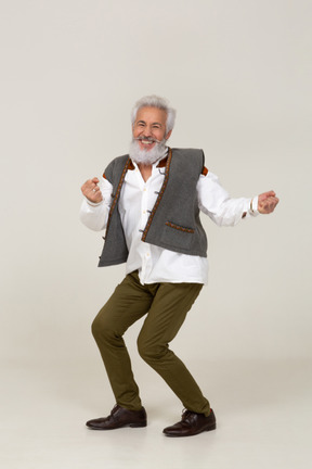 Stylish man smiling widely and dancing