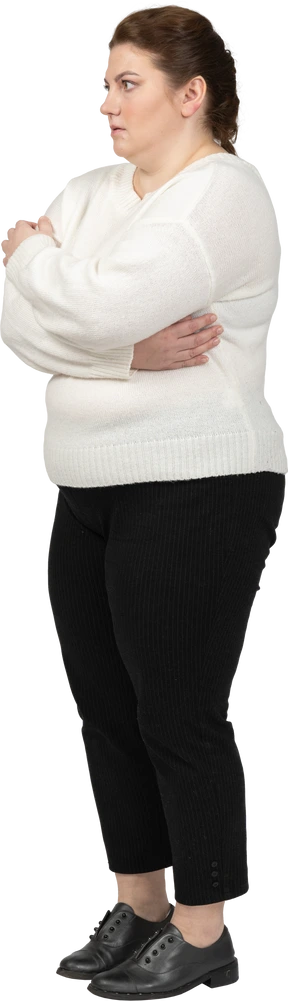 Plus size woman in casual clothes standing in profile with arms crossed