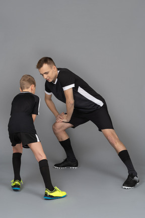 Full-length of a young man coaching little boy making a lunge