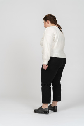 Плюс размер женщина в белом свитере стоя