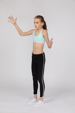 Menina adolescente em roupas esportivas levantando as mãos