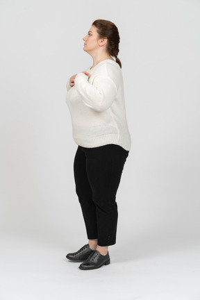 Side view of a plump woman in casual clothes standing