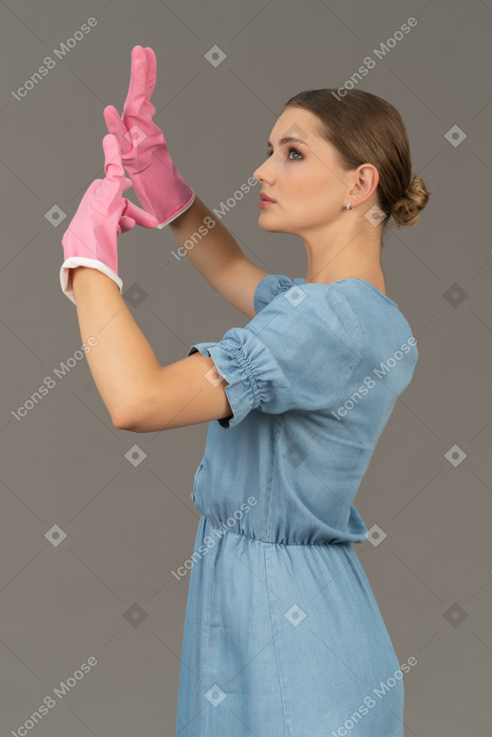 Retrato, de, un, mujer joven, levantar manos, en, látex, guantes