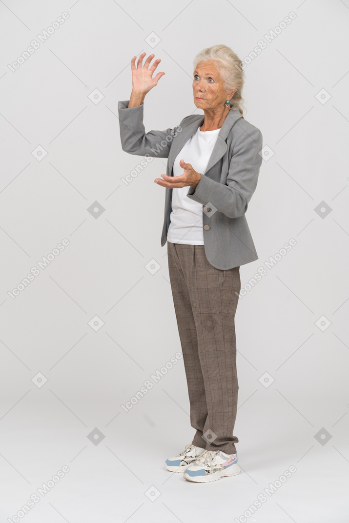 Vue latérale d'une vieille dame en costume montrant la taille de quelque chose