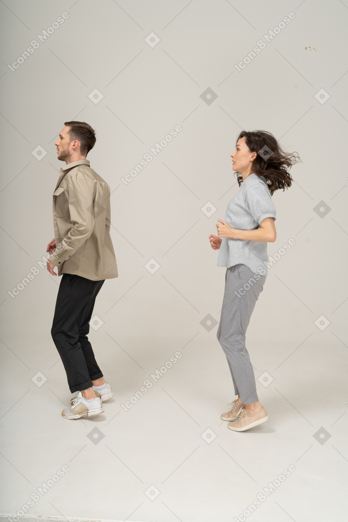 Вид сбоку на молодого мужчину и женщину с согнутыми коленями