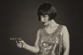 Mujer con peinado bob apuntando la pistola hacia los lados