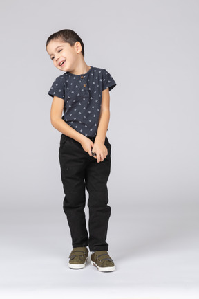 Vista frontal de um menino feliz em roupas casuais olhando para o lado