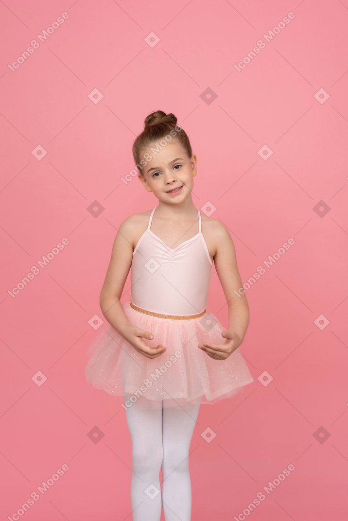 Маленькая девочка стоит в балетной позе
