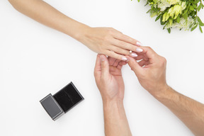 Male hand putting a ring on female hand