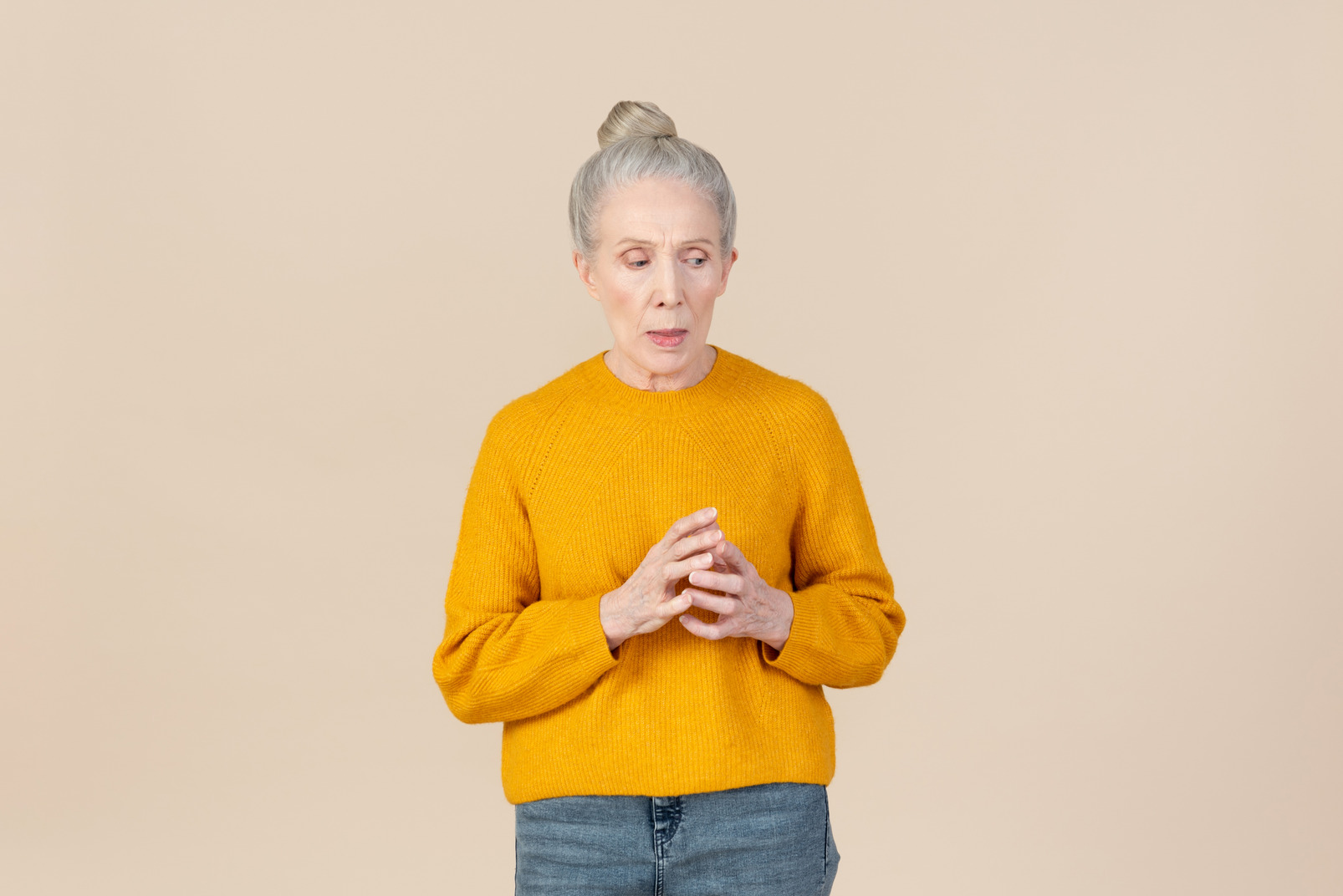 Pensive older woman in a mustard sweater