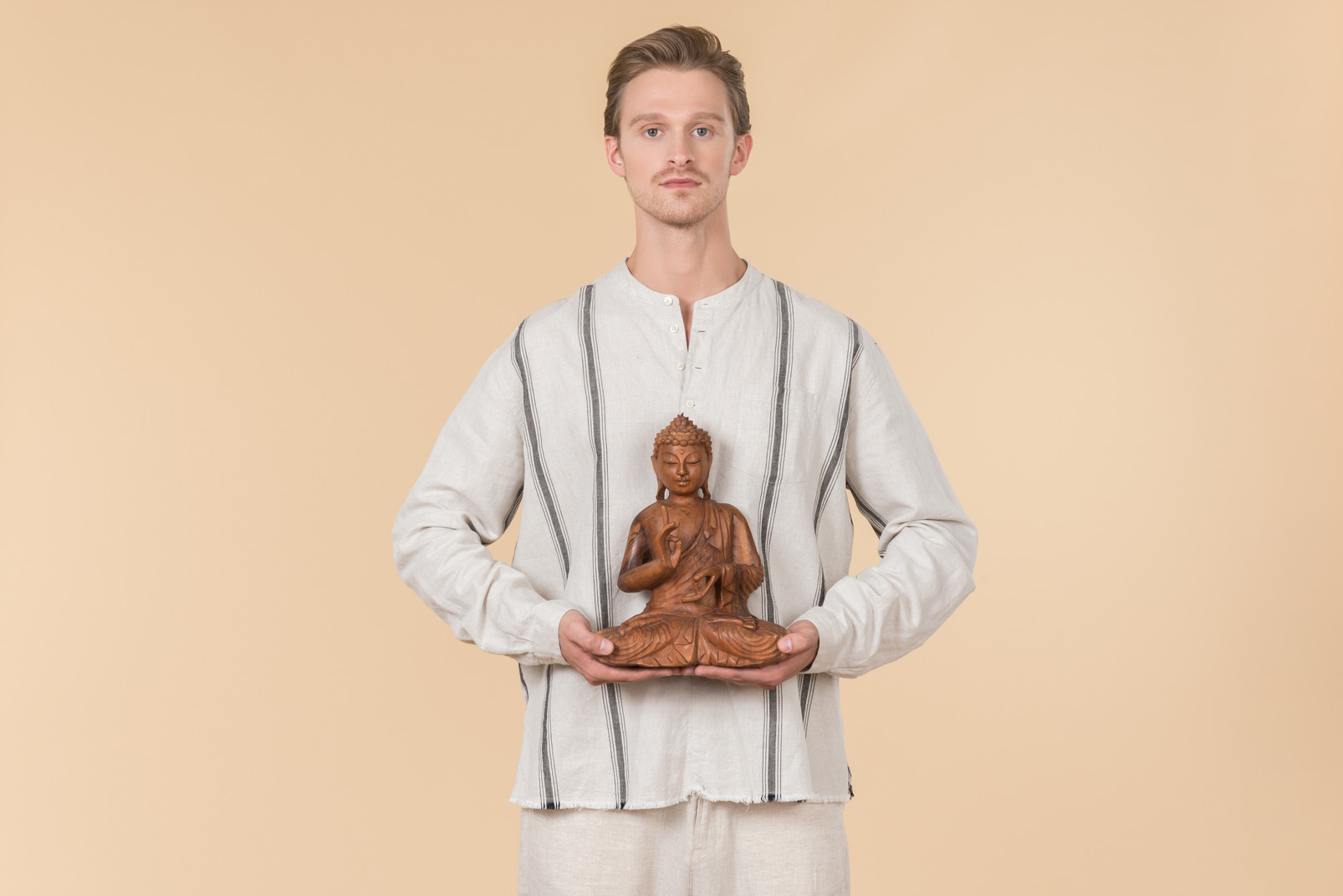 Young man holding buddha statue
