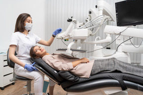 Longitud total de una dentista terminando el examen dental de su paciente