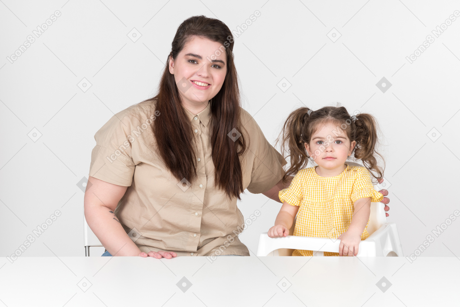 Mother and kid girl daughter in children's chair sitting at the table