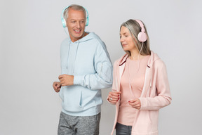 Paar mittleren alters joggen während sie musik hören