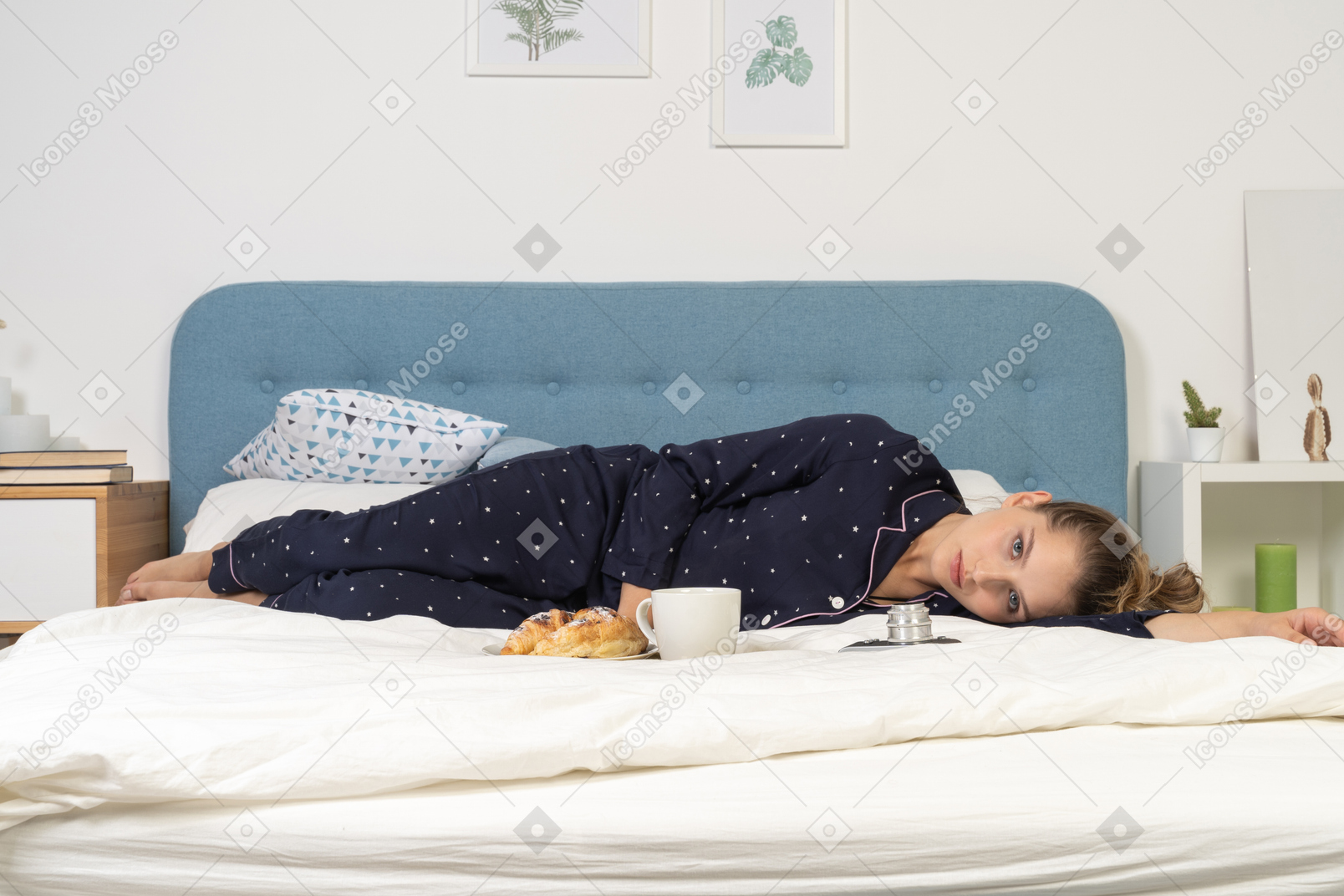 Vue de face d'une pose au lit jeune femme prenant son petit déjeuner