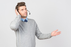 Call center agent touching headset and looking up